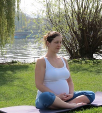 Schwangere Frau in Yogastellung sitzend